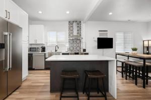a kitchen with a large island with stools in it at Updated Family Friendly Hillyard Gem NEW HOT TUB! in Spokane +52 photos