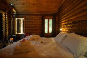 ein Schlafzimmer mit einem Bett in einer Blockhütte in der Unterkunft Estalagem Wiesbaden in Monte Verde + 147 Fotos