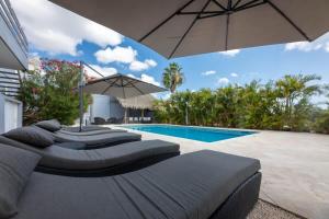 简蒂埃尔Casa di Mama - Ground floor 1-bedroom的一个带两张床和遮阳伞的游泳池