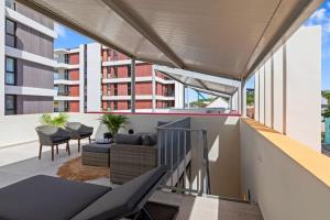 a balcony with a couch and chairs on a building at Island Time Retreat in Willemstad