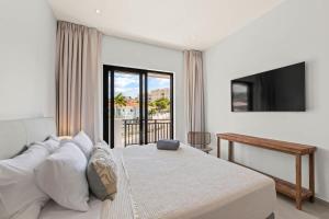 a bedroom with a large bed and a television at Azure Penthouse in Willemstad