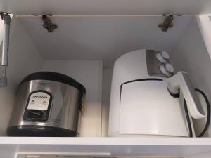 a coffee maker and a toaster sitting on a shelf at Frente ao Parque da Lagoa Quente Entrada NÃO INCLUSA Aptos Particulares com varanda in Caldas Novas