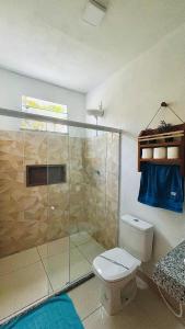 a bathroom with a toilet and a glass shower at Ilha de Boipeba Casa com 2 quartos com ar condicionado no 1ºandar in Cayru