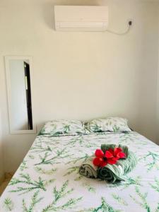 a bed with two towels and two flowers on it at Ilha de Boipeba Casa com 2 quartos com ar condicionado no 1ºandar in Cayru +26 photos