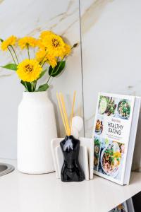 een tafel met een boek en een vaas met gele bloemen bij Menlyn Maine luxury appartment in Vosburg