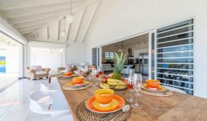 a dining room with a table with plates of food at Villa Star Beach - Private pool and sea view! in Willemstad