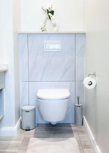 een witte badkamer met een toilet en een wastafel bij Menlyn Maine luxury appartment in Vosburg