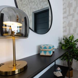 een tafel met een spiegel en een lamp erop bij Penthouse Mesa Bonita in Jan Thiel