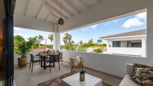 a living room with a table and chairs on a balcony at The Wave - Excellently located Penthouse with pool in Jan Thiel