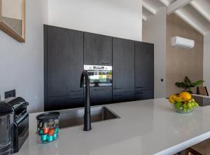 a kitchen with a sink and a counter with a bowl of fruit at The Wave - Excellently located Penthouse with pool in Jan Thiel