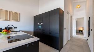 a kitchen with black cabinets and a black refrigerator at The Wave - Excellently located Penthouse with pool in Jan Thiel +15 photos
