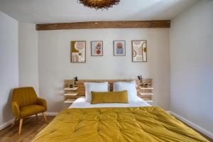 Salignac EyviguesMaison T3 tout confort et spa Le Clos des Pierres的带一张大床和一把椅子的卧室