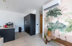 a hallway with a mural of palm trees on the wall at Palm Suite - Newly constructed poolside apartment just minutes from the beach in Jan Thiel