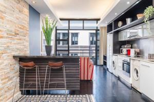 une cuisine avec un comptoir et deux tabourets dans l'établissement Heritage-Chic Apartment in Cape Town, au Cap