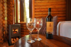 eine Flasche Wein und zwei Weingläser auf einem Tisch in der Unterkunft Estalagem Wiesbaden in Monte Verde