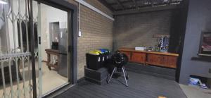 a room with a balcony with a glass door at Lazey Bazely Beach Cottage in Bazley Beach +5 photos