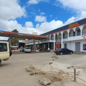 a gas station with cars parked in a parking lot at Crown Accommodation Narok in Narok