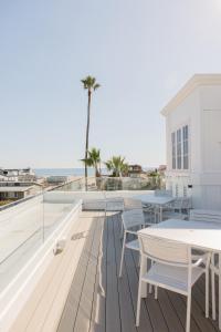 a balcony with tables and chairs and the ocean at Bay Shores Peninsula Hotel in Newport Beach