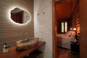 ein Badezimmer mit einem Waschbecken und ein Schlafzimmer mit einem Bett in der Unterkunft Estalagem Wiesbaden in Monte Verde