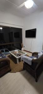 a living room with two chairs and a coffee table at Lazey Bazely Beach Cottage in Bazley Beach
