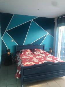 a bedroom with a bed with a blue wall at petite maison calme in Hourtin