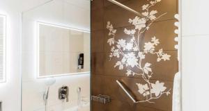 a bathroom with a shower with a brown wall at Erlebnishotel "Zur Schiffsmühle" GmbH in Höfgen +43 photos