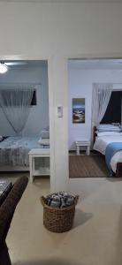 a bedroom with two beds and a basket in the foreground at Lazey Bazely Beach Cottage in Bazley Beach