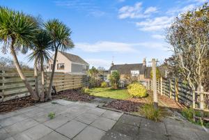 FerrydenにあるWild Berry Stays- Ferrydenの塀と椰子の木が植えられた裏庭
