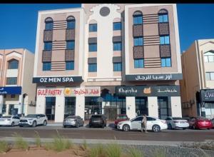 a large building with cars parked in front of it at Fully furnished bedroom c-136 in Abu Dhabi