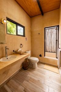 a bathroom with a sink and a toilet and a window at Xtambaa Selva in Tulum +40 photos
