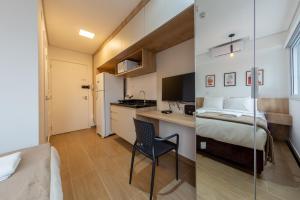 a hotel room with a bed and a desk and a chair at BHomy Romana in Sao Paulo