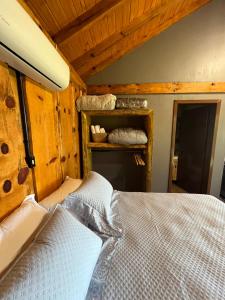 a bedroom with a bed in a wooden room at Chalé Refúgio Panorâmico in Canela +19 photos