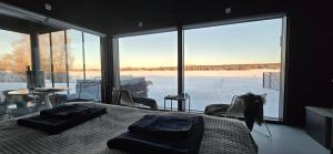 a bedroom with a bed and a large window at Riverside villa with sauna and jacuzzi in Rovaniemi