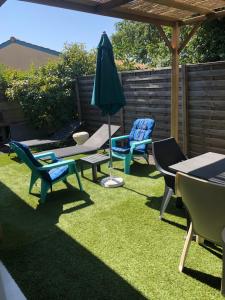 a patio with chairs and a table and an umbrella at petite maison calme in Hourtin