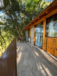 a deck of a cabin with a bench on it at Chalé Refúgio Panorâmico in Canela