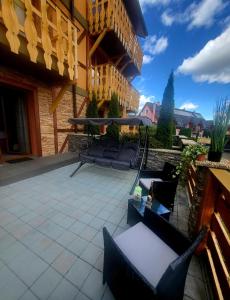 a patio with chairs and tables on a building at Apartmán Andrea Tatragolf in Veľká Lomnica