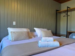 - un lit avec 2 oreillers et 2 serviettes dans l'établissement Hotel Solar da Montanha, à Campos do Jordão