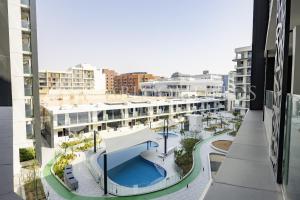 an aerial view of a building with a swimming pool at Bloomfields Elegant Pool View Stu The Gate in Abu Dhabi Intl
