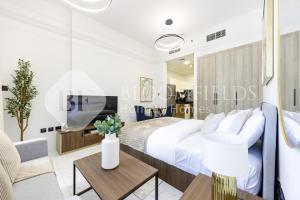 Un dormitorio con una cama y una sala de estar. en Bloomfields Elegant Pool View Stu The Gate, en Abu Dhabi Intl