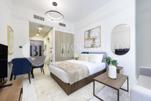 Un dormitorio con una cama y un comedor. en Bloomfields Elegant Pool View Stu The Gate, en Abu Dhabi Intl 3 fotos más