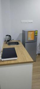 シンガポールにあるThe Family Suites Serviced Apartmentsのキッチン(シンクと冷蔵庫付きのカウンター付)