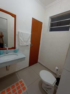 a bathroom with a toilet and a sink and a mirror at Terral Casa de Praia in Guarujá +25 photos