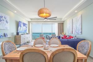 a dining room with a table and chairs and a couch at Beautiful 2 bedroom condo Encantame Tower E 802 in Puerto Peñasco