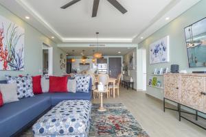 a living room with a blue couch and a kitchen at Beautiful 2 bedroom condo Encantame Tower E 802 in Puerto Peñasco