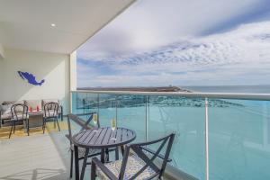 a balcony with a table and chairs and a view of the ocean at Beautiful 2 bedroom condo Encantame Tower E 802 in Puerto Peñasco