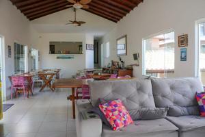 a living room with a couch and a dining room at Pousada CafeMar Búzios in Búzios