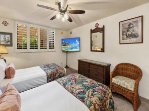 a bedroom with two beds and a tv and a chair at Polo Beach Club 102 in Wailea +29 photos