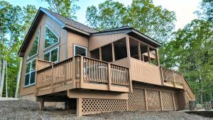 a house with a large deck on top of it at Eaglet Cabin near the Shenandoah River in Oak Hill