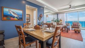a dining room and living room with a table and chairs at Encantame Towers Verano 1401 in Playa Encanto