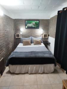 a bedroom with a bed with a tv on the wall at Bruna Zona Alta in San Fernando del Valle de Catamarca